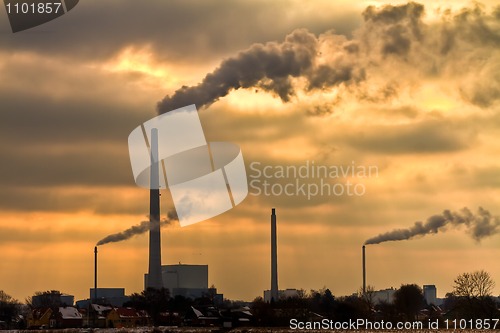 Image of Power plant with burning yellow sky behind