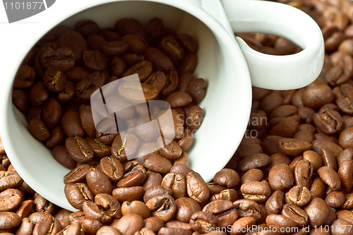 Image of White cup in coffee beans