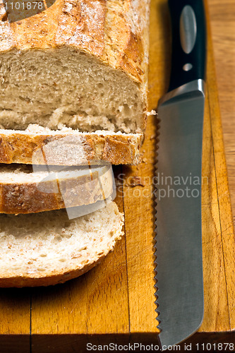 Image of White bread and knife on wooden cutting board