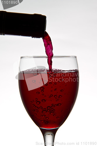 Image of red wine pouring down from a wine bottle