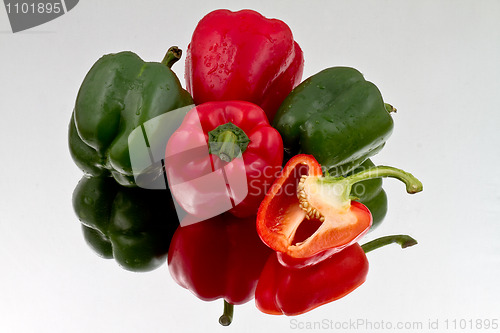 Image of Red and green bell peppers on reflective bacground