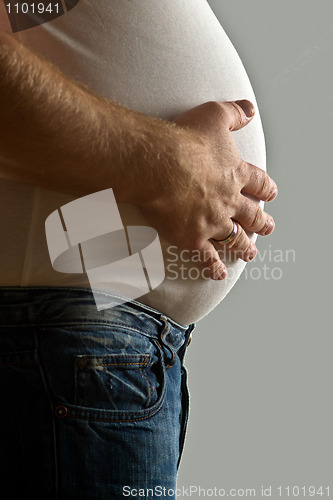 Image of Overweight man with hand on belly