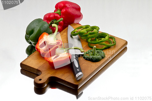 Image of Bell peppers being cutted at wooden cutting board