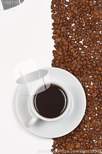 Image of Coffee in white cup on saucer placed cofee beans 