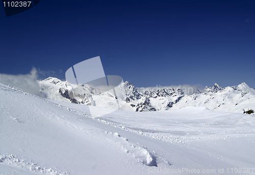 Image of Ski slope against mountain peaks