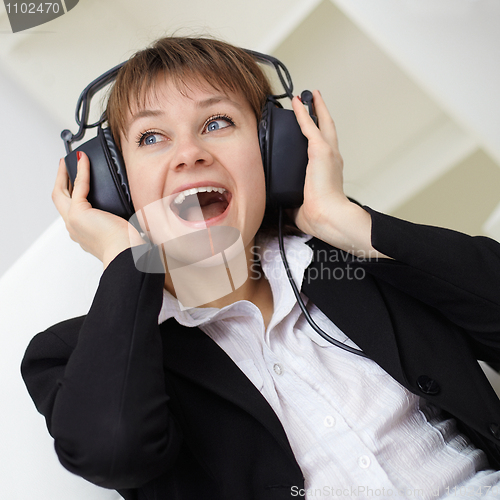 Image of Ð¡heerful woman singing in ear-phones