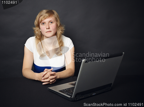 Image of Woman sits at table with computer