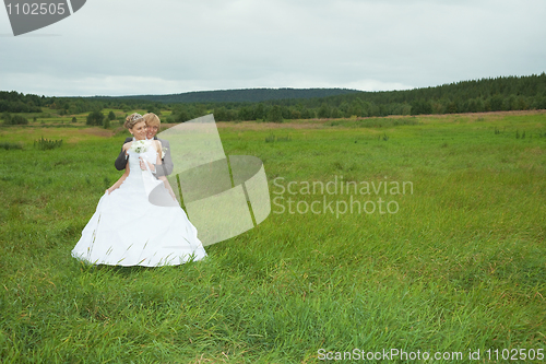 Image of Groom embraces the favorite bride in field