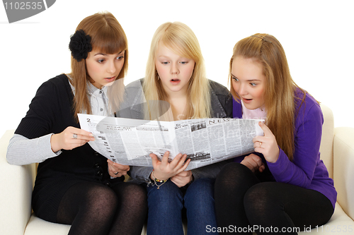 Image of Three young girls reading newspaper