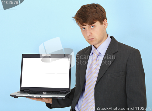 Image of Serious businessman holds on hand laptop