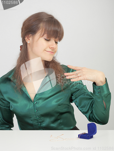 Image of Young woman admires new jewel