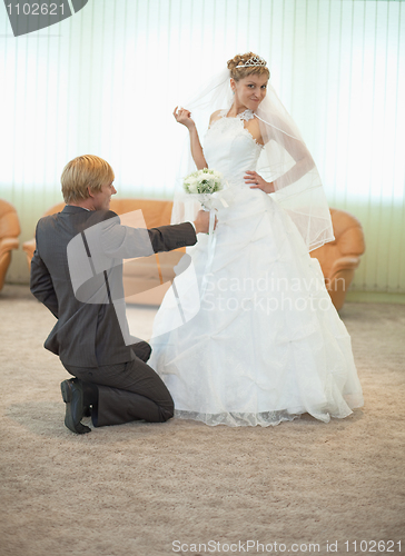 Image of Groom with bride funny pose in hall