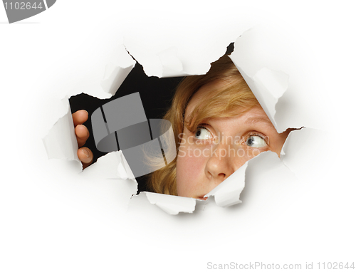 Image of Woman looks out of hole with curiosity