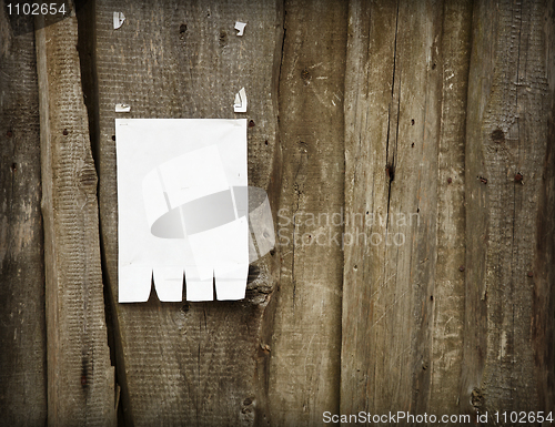 Image of Paper advertisement on wooden fence