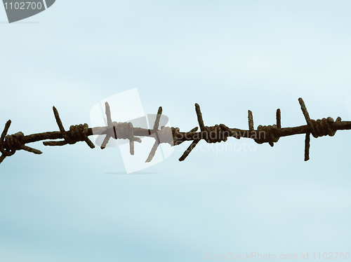 Image of Ancient rusty barbed wire against sky