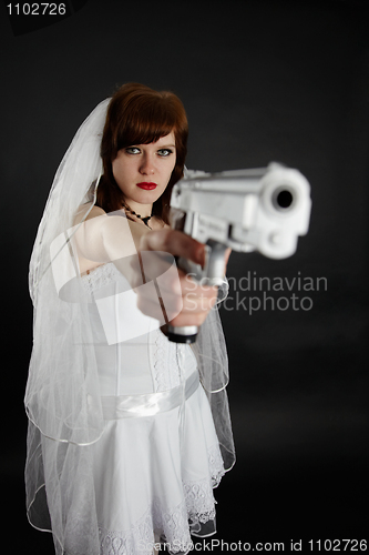 Image of Serious bride take aim with a pistol