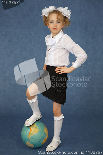 Image of Schoolgirl put foot on globe