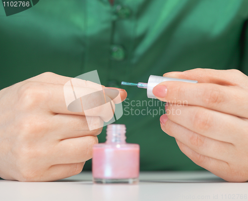 Image of Woman covers nail varnish - close-up of hands