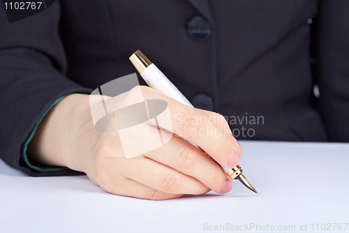 Image of Person undersigns an golden pen