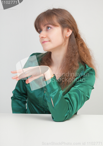 Image of Coquettish beautiful girl sits at table