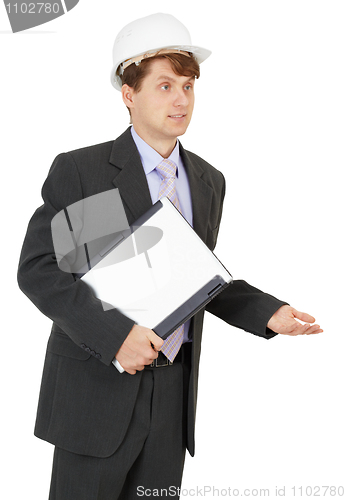 Image of Young specialist in helmet with laptop