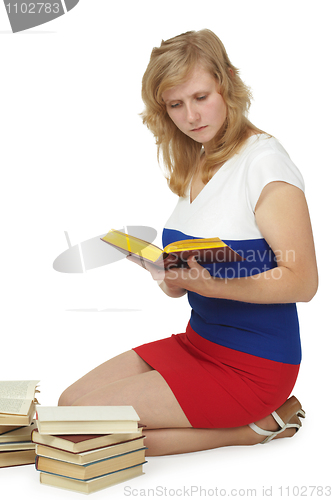 Image of Girl reads lot of books sitting on floor