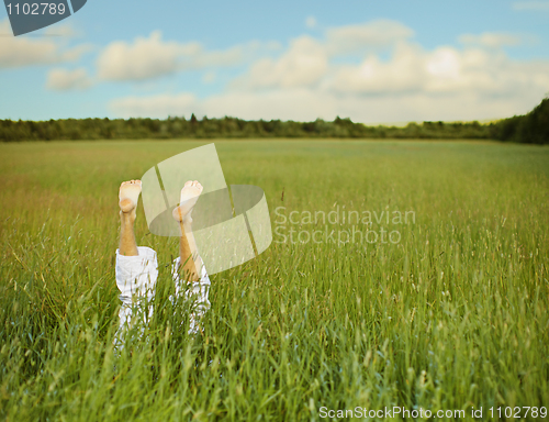 Image of Bare feet from green grass