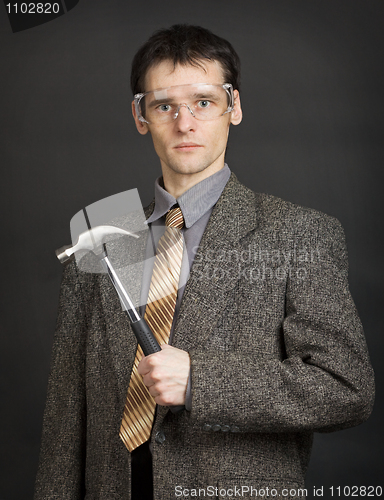 Image of Man in goggles keeps in readiness a hammer
