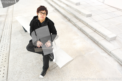 Image of man using computer outdoor