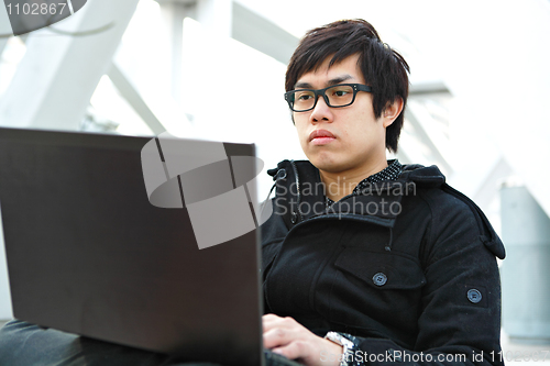 Image of Man using computer outdoors