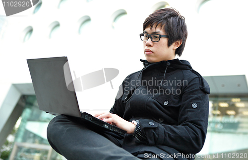 Image of Man using a laptop outdoors