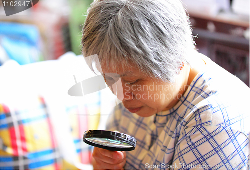 Image of senior woman using magnifier