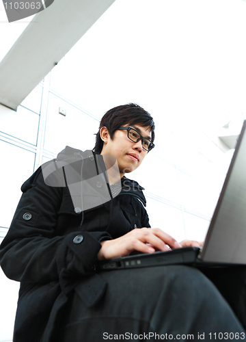 Image of Man using computer outdoors