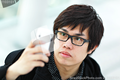 Image of young man taking picture with mobile phone