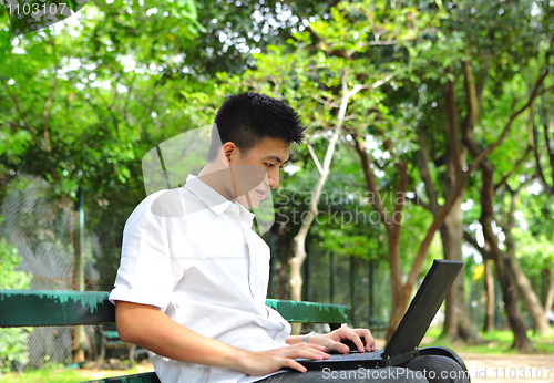 Image of man using computer outdoor