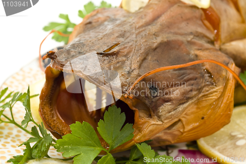 Image of Closeup of Bloated sheatfish head with lemon and parsley