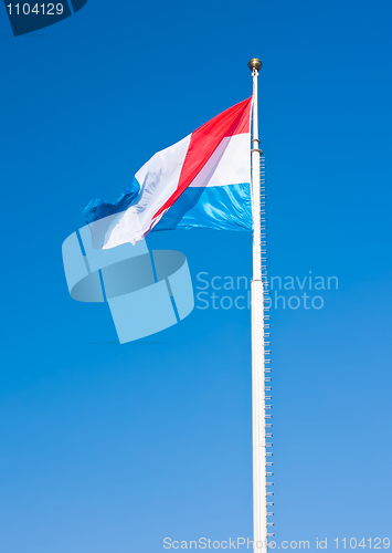 Image of Flag of Luxembourg over blue sky