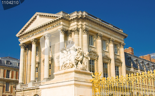 Image of Statue and palace facade with columns in Versailles
