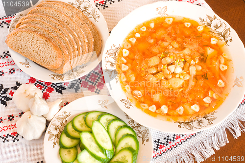 Image of Borsch, black bread and sliced cucumber