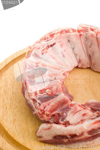 Image of Raw Pork ribs with meat on round hardboard