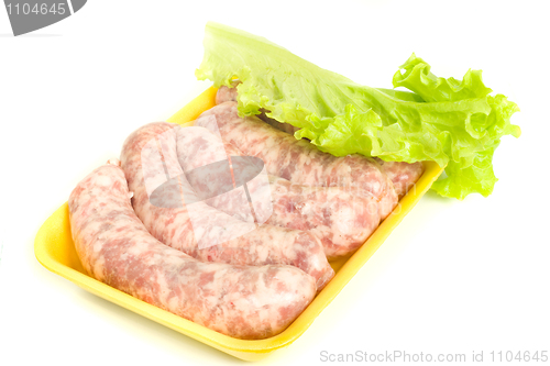 Image of Uncooked Sausages and salad leaf