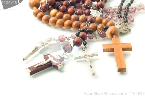 Image of Rosary beads over white with focus on crosses 