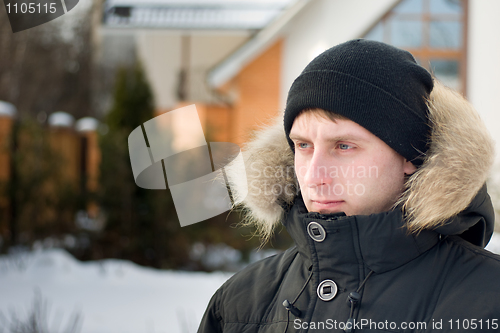 Image of Winter holidays - man in cap and warm jacket 