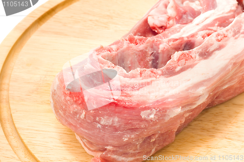 Image of Raw pork meat on round hardboard