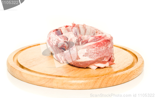 Image of Uncooked pork meat on round hardboard