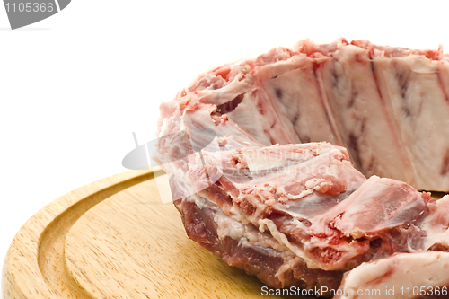 Image of Pork ribs with raw meat on round hardboard