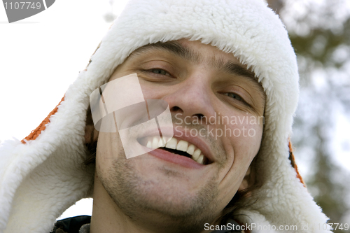 Image of The young man in a winter cap against the sky