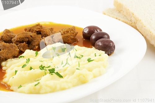 Image of Goulash with potato puree, olives and bread