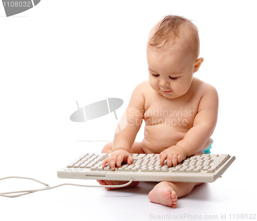 Image of Little child is typing on keyboard