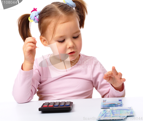 Image of Little girl plays with money